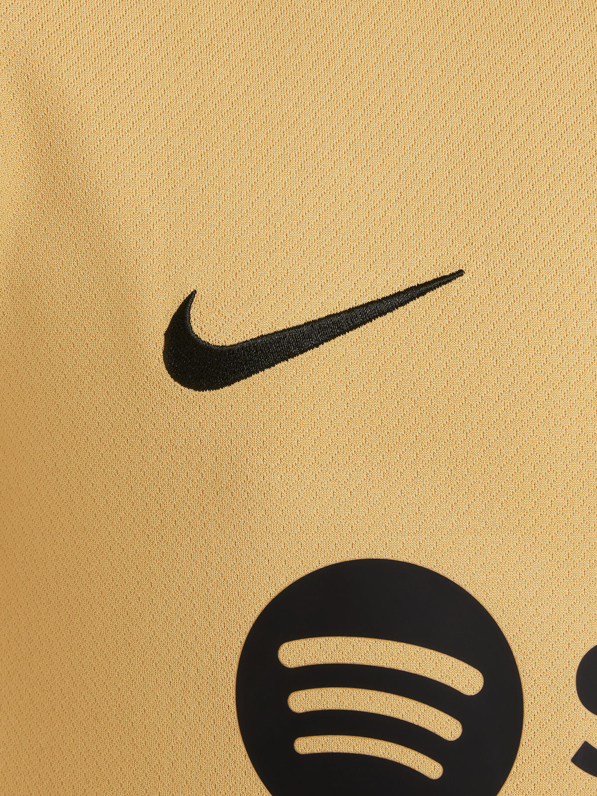 Two children wearing FC Barcelona gold training kits with short sleeves, featuring red and blue shoulder stripes, Nike logos, and Spotify sponsor branding.