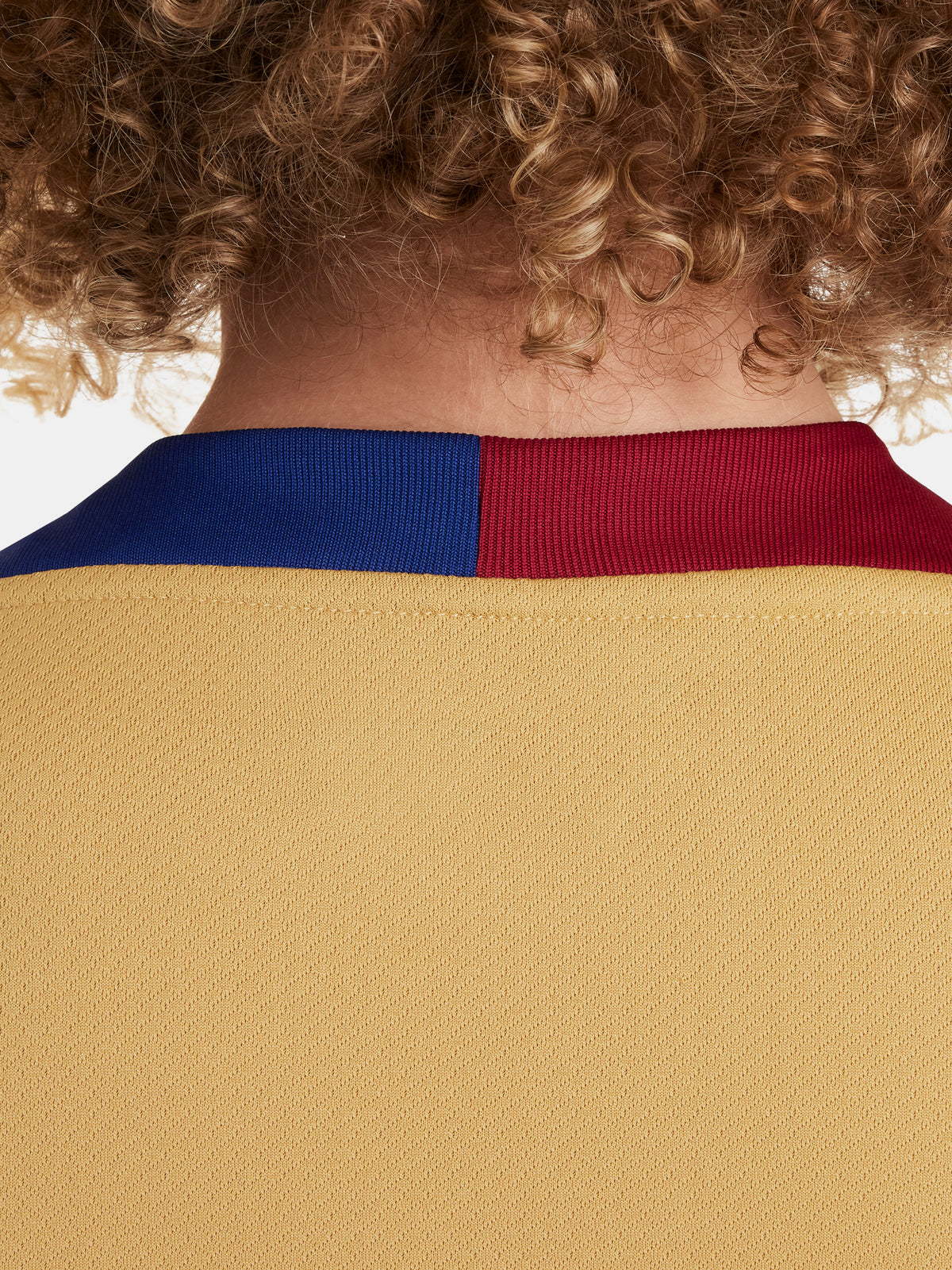 Two children wearing FC Barcelona gold training kits with short sleeves, featuring red and blue shoulder stripes, Nike logos, and Spotify sponsor branding.