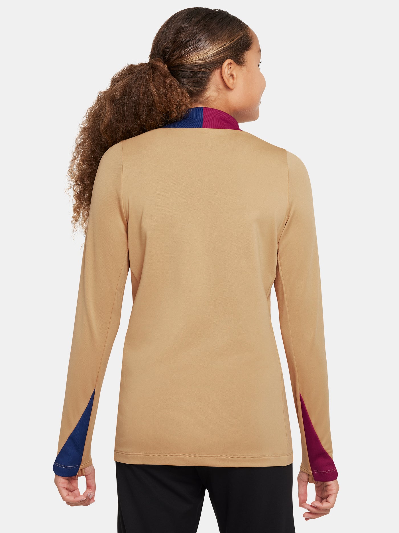 Girl wearing a long-sleeve FC Barcelona gold training top with a quarter-zip, red and blue shoulder accents, Nike logo, and Spotify sponsor logo.