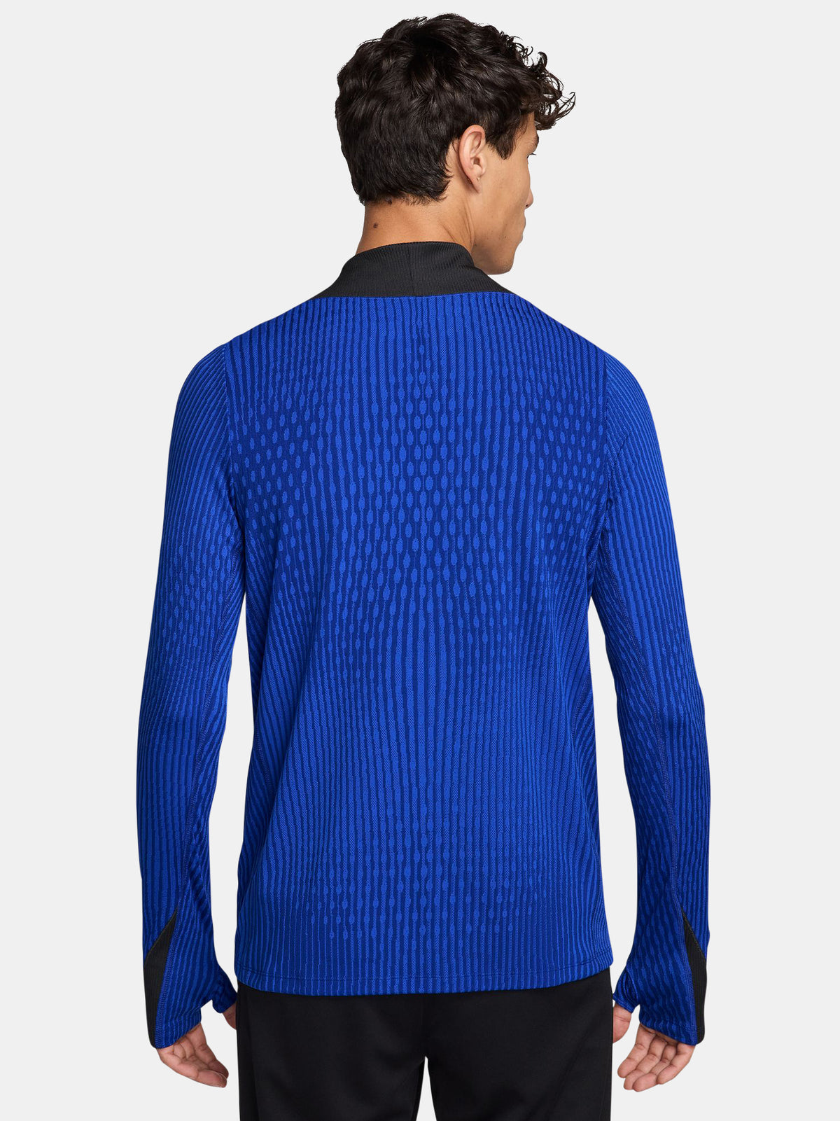 FC Barcelona long-sleeve training top in bright royal blue with vertical textured lines. Features neon green Spotify sponsor logo in the center, Nike logo on the right chest, and FC Barcelona crest on the left chest. Shoulders and upper sleeves have black accents.