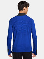 FC Barcelona long-sleeve training top in bright royal blue with vertical textured lines. Features neon green Spotify sponsor logo in the center, Nike logo on the right chest, and FC Barcelona crest on the left chest. Shoulders and upper sleeves have black accents.