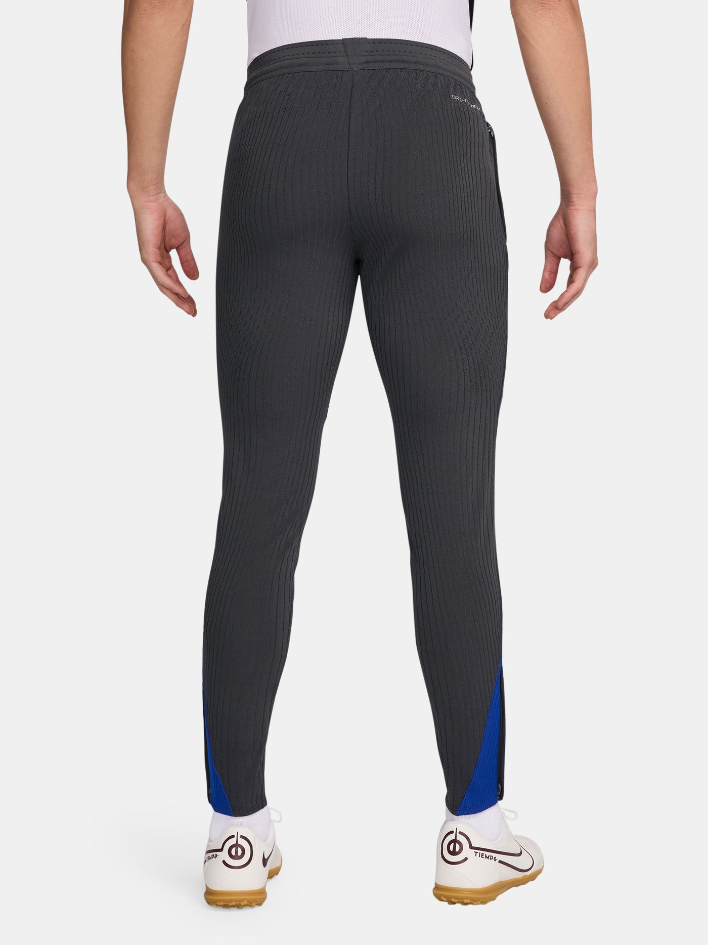 FC Barcelona dark grey tapered training pants with a subtle striped pattern, featuring a neon green Nike logo on the right thigh and the FC Barcelona crest in neon green on the left thigh.