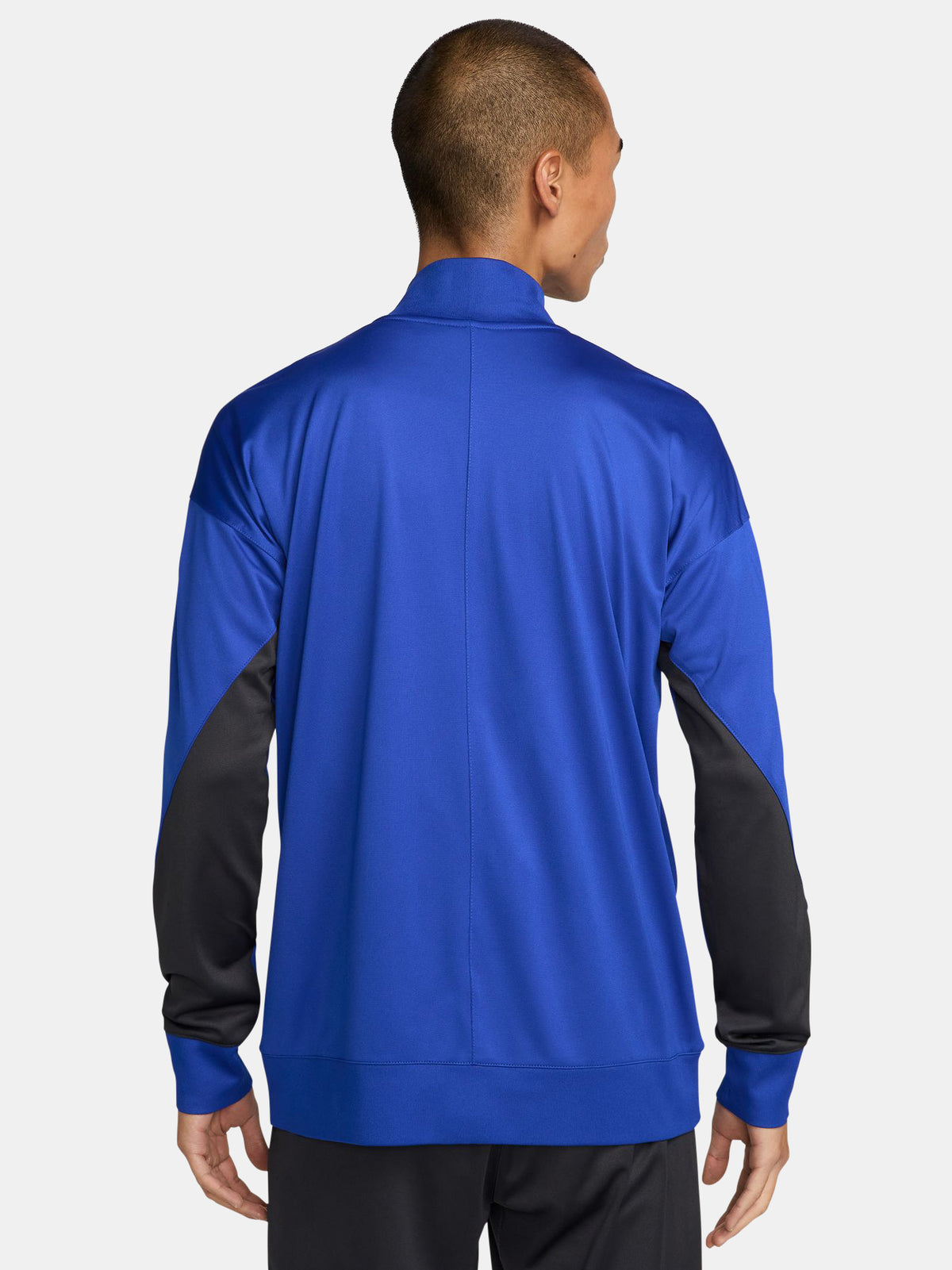 FC Barcelona blue full-zip training jacket featuring neon green Nike logo on the right chest and the FC Barcelona crest with Spotify sponsor on the left chest. Black accents on the lower sleeves. Paired with black training pants.
