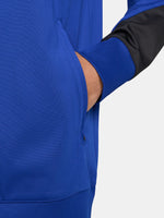 FC Barcelona blue full-zip training jacket featuring neon green Nike logo on the right chest and the FC Barcelona crest with Spotify sponsor on the left chest. Black accents on the lower sleeves. Paired with black training pants.