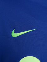 Women's FC Barcelona long-sleeve training top in vibrant royal blue with black shoulder accents, featuring light green Nike, Spotify, and club logos on the chest.