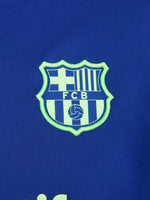 Women's FC Barcelona long-sleeve training top in vibrant royal blue with black shoulder accents, featuring light green Nike, Spotify, and club logos on the chest.