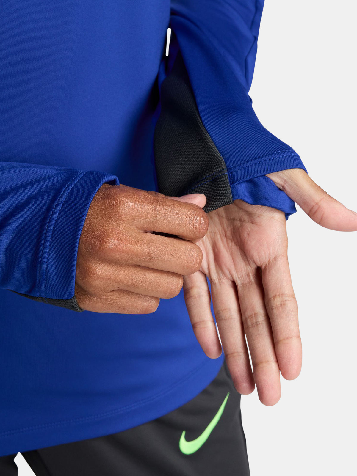 Women's FC Barcelona long-sleeve training top in vibrant royal blue with black shoulder accents, featuring light green Nike, Spotify, and club logos on the chest.
