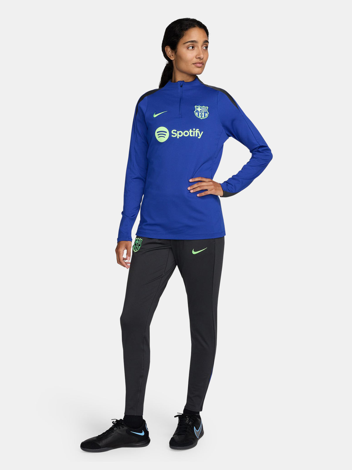 Women's FC Barcelona long-sleeve training top in vibrant royal blue with black shoulder accents, featuring light green Nike, Spotify, and club logos on the chest.