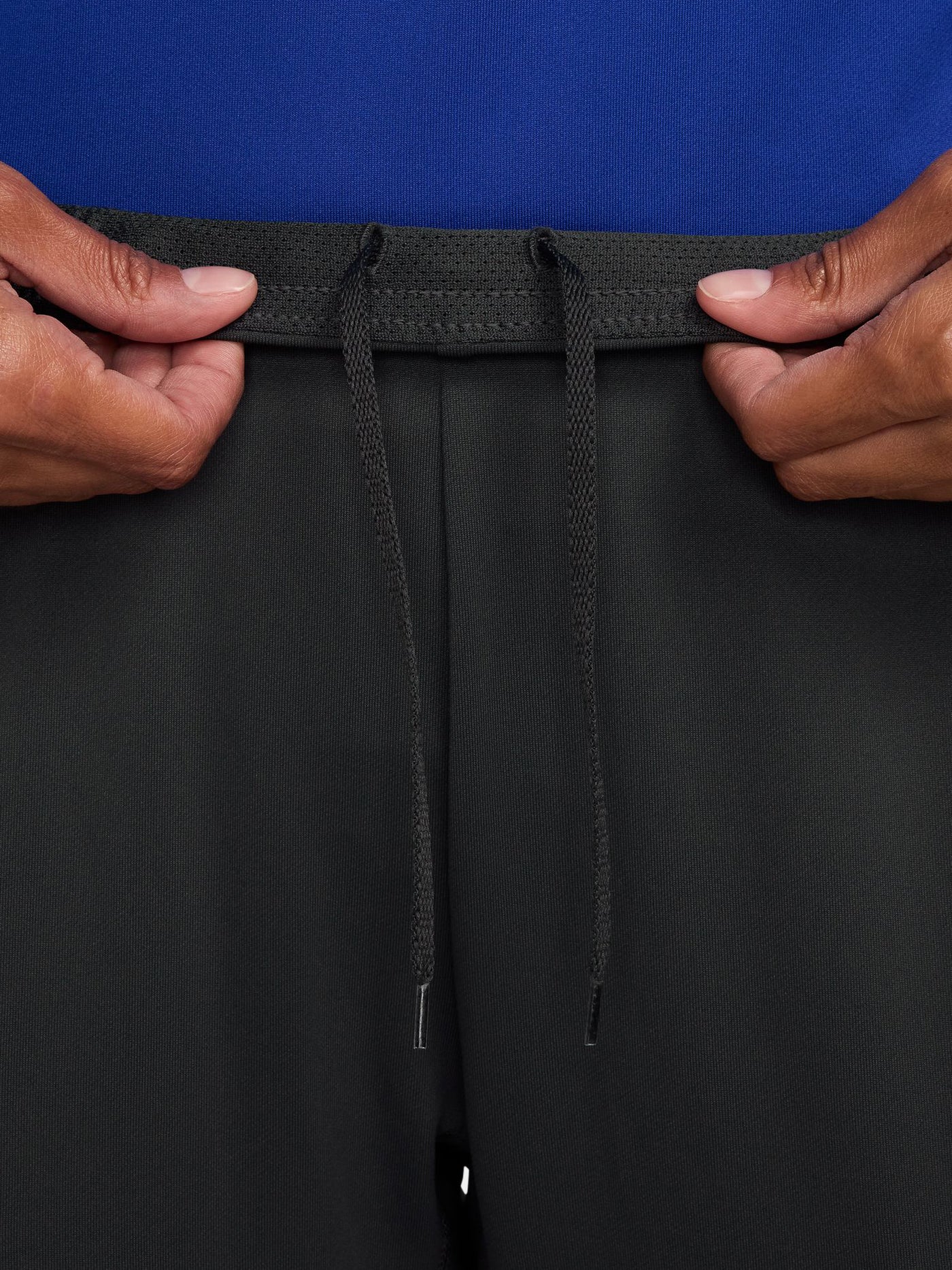 Black FC Barcelona track pants with neon green Nike logo and club crest.