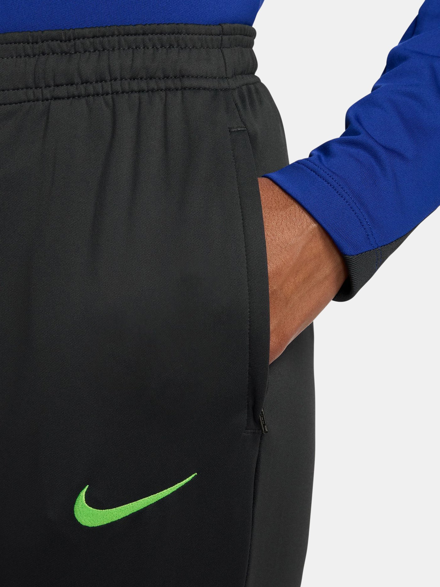 Black FC Barcelona track pants with neon green Nike logo and club crest.