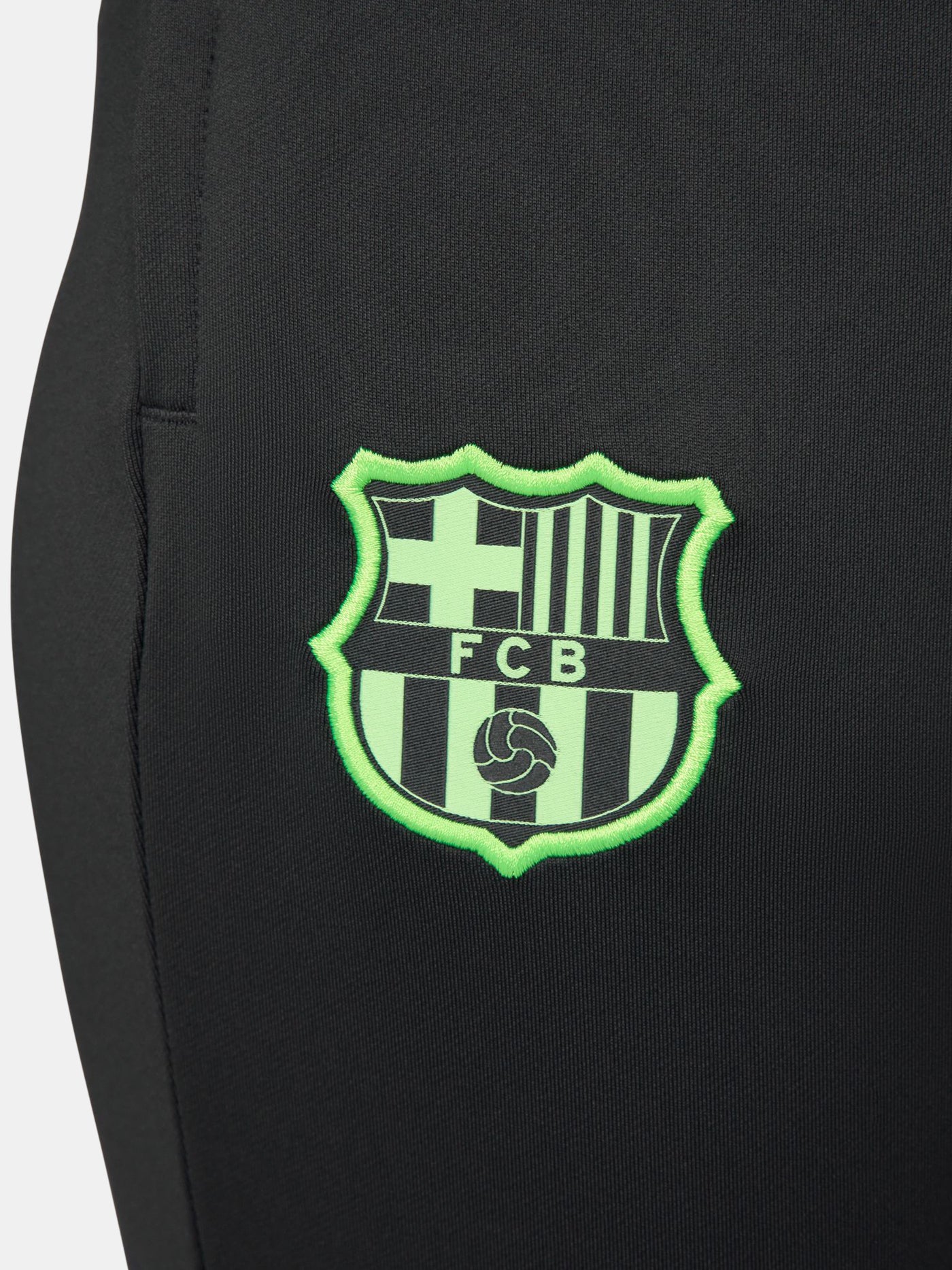 Black FC Barcelona track pants with neon green Nike logo and club crest.
