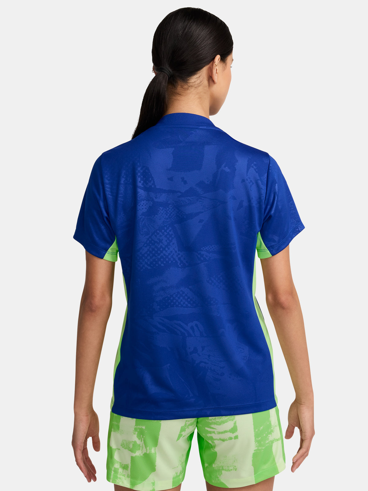 Women's FC Barcelona blue training jersey with neon green logos and side details.
