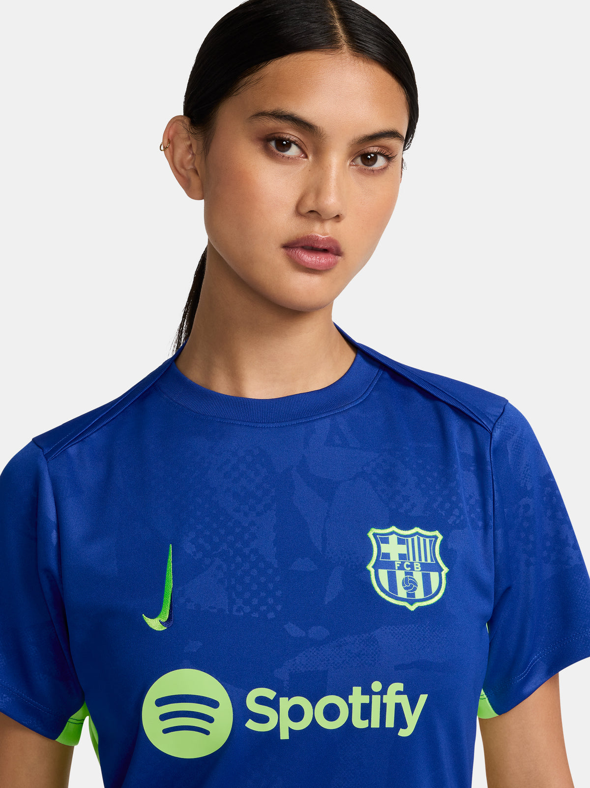 Women's FC Barcelona blue training jersey with neon green logos and side details.