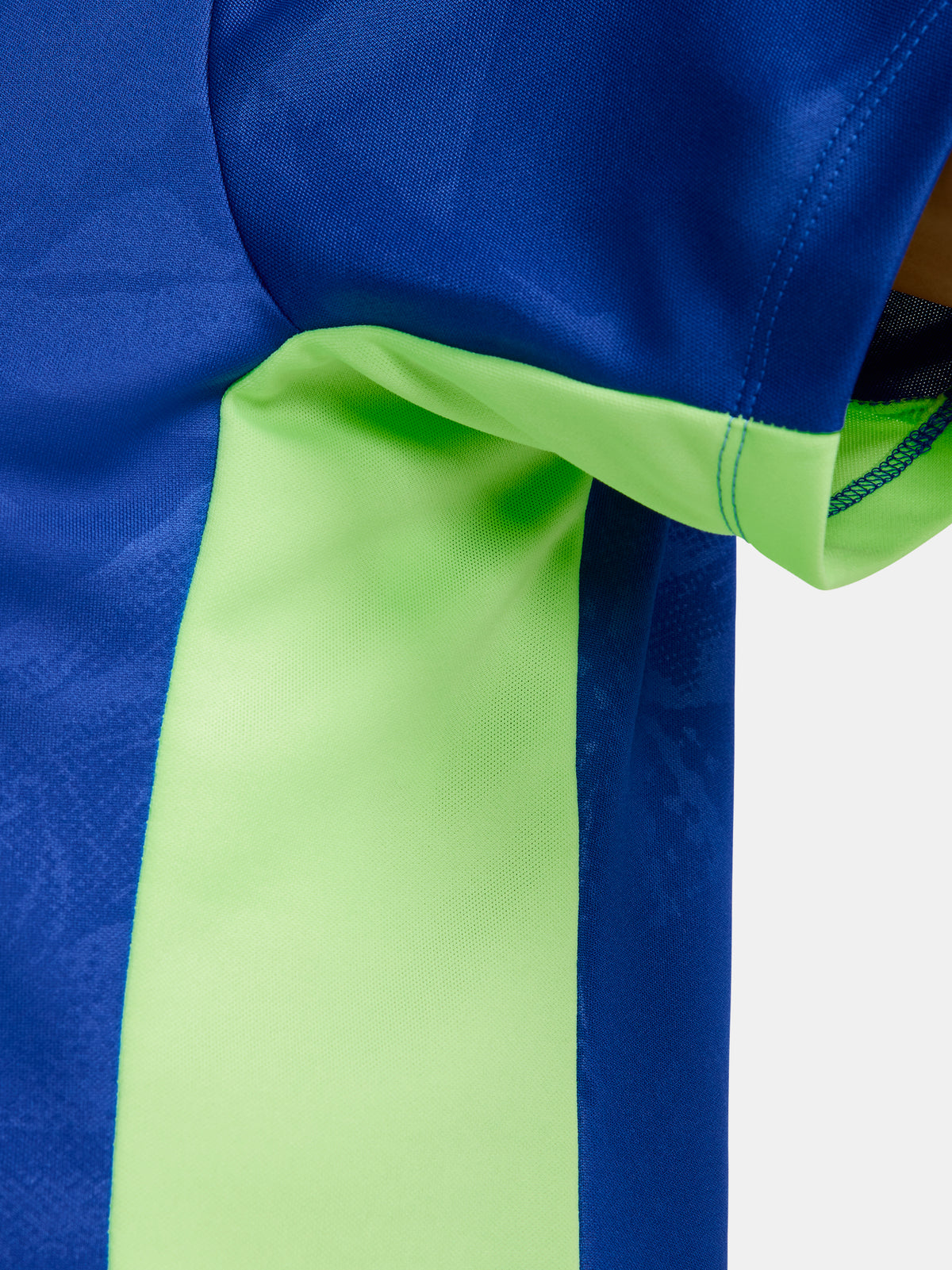 Women's FC Barcelona blue training jersey with neon green logos and side details.