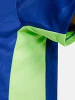 Women's FC Barcelona blue training jersey with neon green logos and side details.