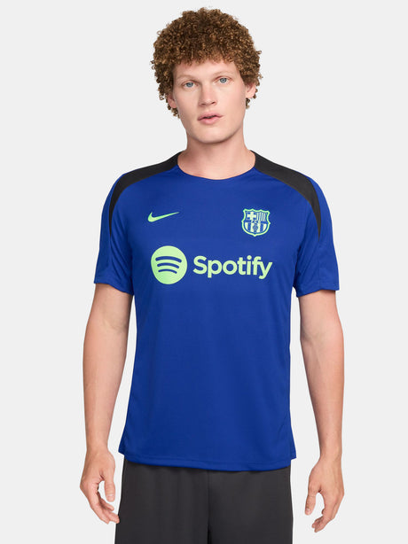 FC Barcelona training shirt in bright royal blue with black shoulder panels. The shirt features neon green logos: a Nike swoosh on the right chest, the FC Barcelona crest on the left chest, and the Spotify sponsor logo prominently across the center.