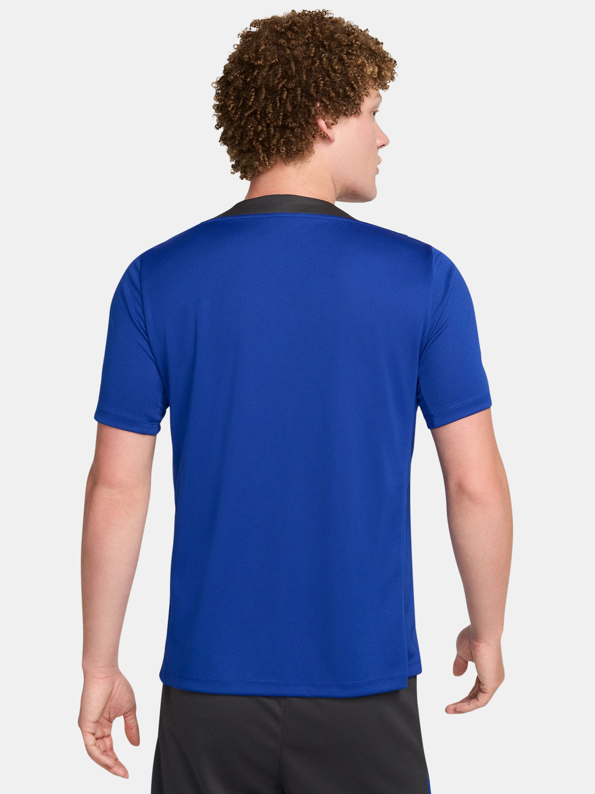 FC Barcelona training shirt in bright royal blue with black shoulder panels. The shirt features neon green logos: a Nike swoosh on the right chest, the FC Barcelona crest on the left chest, and the Spotify sponsor logo prominently across the center.