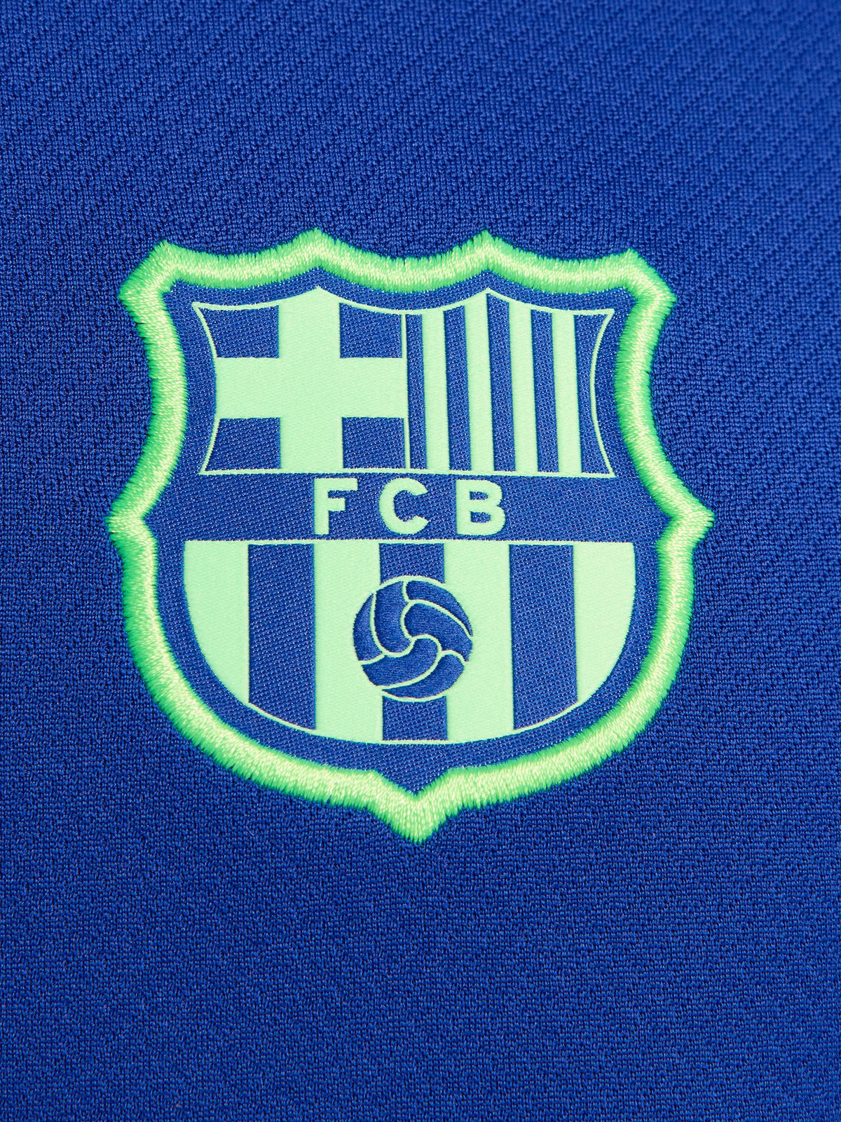 FC Barcelona training shirt in bright royal blue with black shoulder panels. The shirt features neon green logos: a Nike swoosh on the right chest, the FC Barcelona crest on the left chest, and the Spotify sponsor logo prominently across the center.