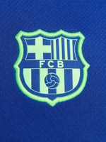 FC Barcelona training shirt in bright royal blue with black shoulder panels. The shirt features neon green logos: a Nike swoosh on the right chest, the FC Barcelona crest on the left chest, and the Spotify sponsor logo prominently across the center.