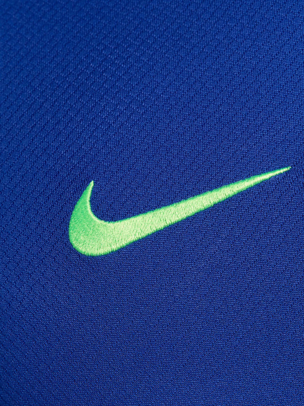 FC Barcelona training shirt in bright royal blue with black shoulder panels. The shirt features neon green logos: a Nike swoosh on the right chest, the FC Barcelona crest on the left chest, and the Spotify sponsor logo prominently across the center.