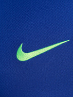 FC Barcelona training shirt in bright royal blue with black shoulder panels. The shirt features neon green logos: a Nike swoosh on the right chest, the FC Barcelona crest on the left chest, and the Spotify sponsor logo prominently across the center.