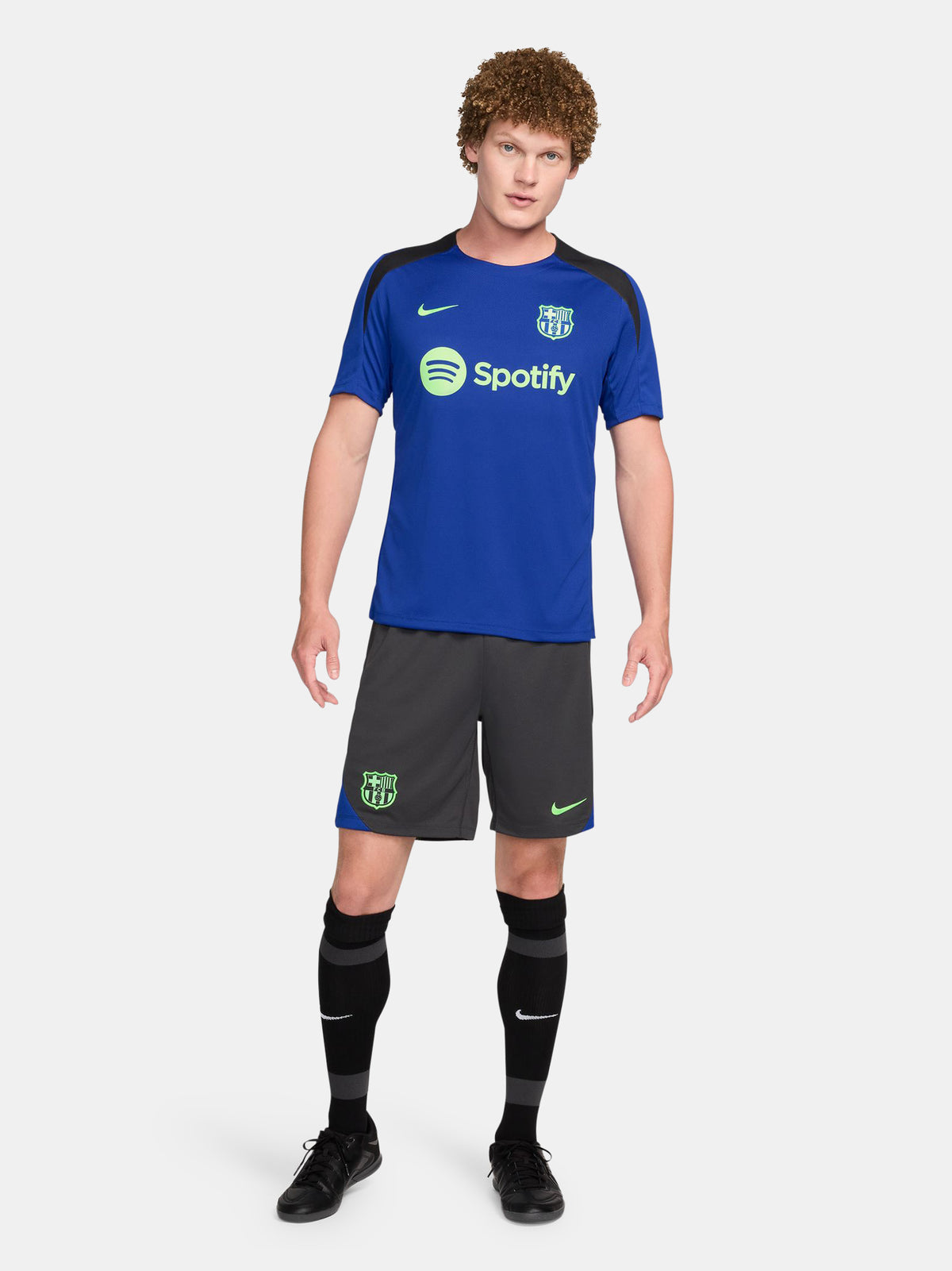 FC Barcelona training shirt in bright royal blue with black shoulder panels. The shirt features neon green logos: a Nike swoosh on the right chest, the FC Barcelona crest on the left chest, and the Spotify sponsor logo prominently across the center.