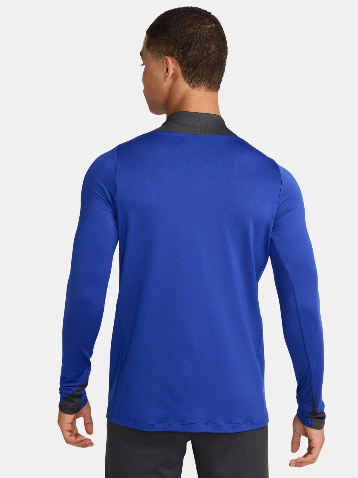 Men's FC Barcelona training kit consisting of a blue long-sleeve top with neon green Nike, Spotify, and club logos, paired with black training pants featuring matching neon green branding.