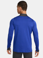 Men's FC Barcelona training kit consisting of a blue long-sleeve top with neon green Nike, Spotify, and club logos, paired with black training pants featuring matching neon green branding.