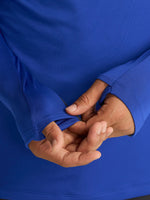 Men's FC Barcelona training kit consisting of a blue long-sleeve top with neon green Nike, Spotify, and club logos, paired with black training pants featuring matching neon green branding.