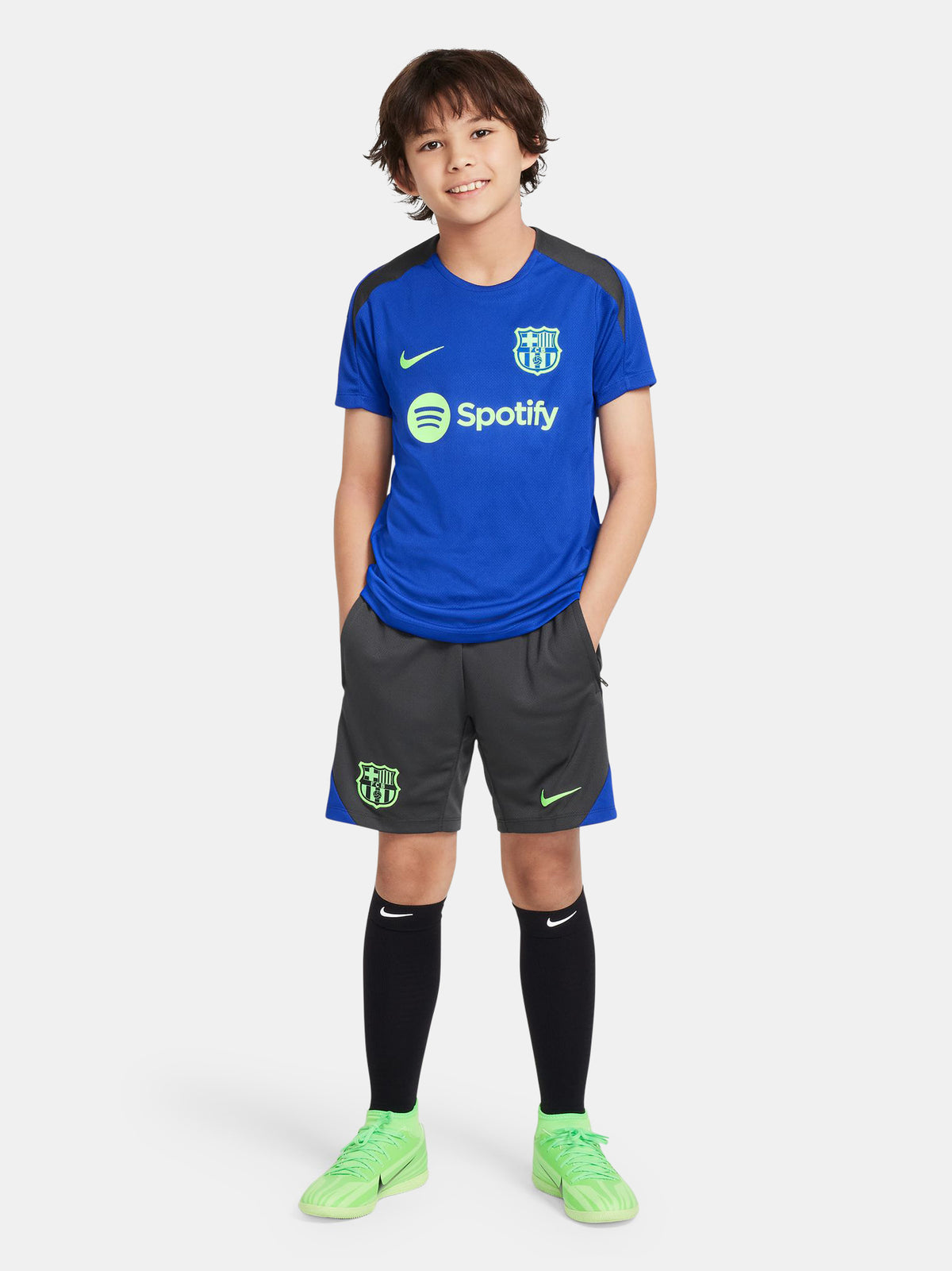 Blue FC Barcelona training jersey with neon green logos and black shoulder panels.