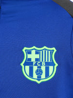 Blue FC Barcelona quarter-zip training top with neon green logos and black shoulder accents.