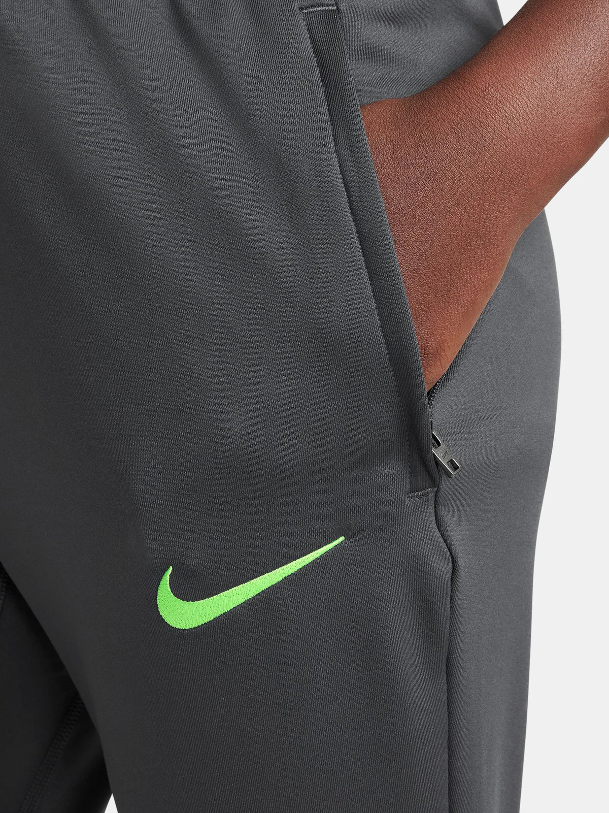 Black FC Barcelona training pants with neon green crest and Nike logo.