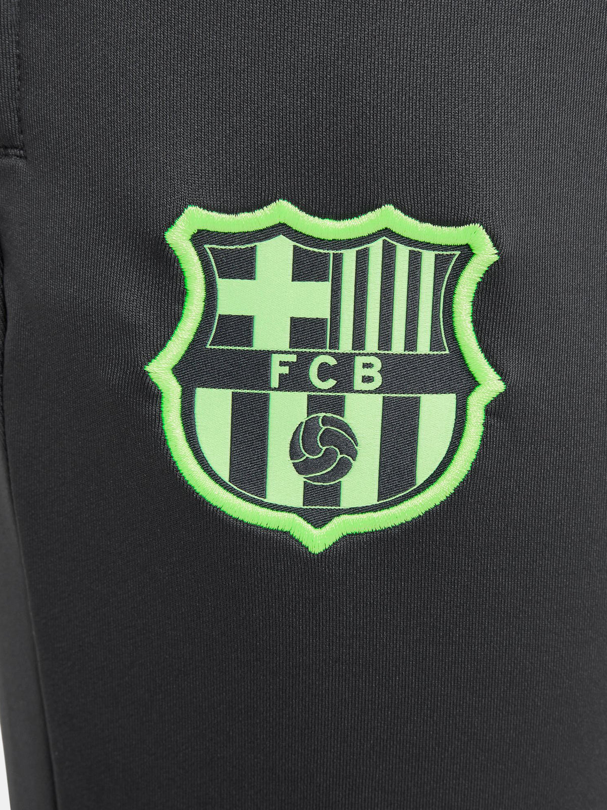 Black FC Barcelona training pants with neon green crest and Nike logo.