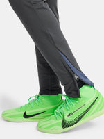 Black FC Barcelona training pants with neon green crest and Nike logo.