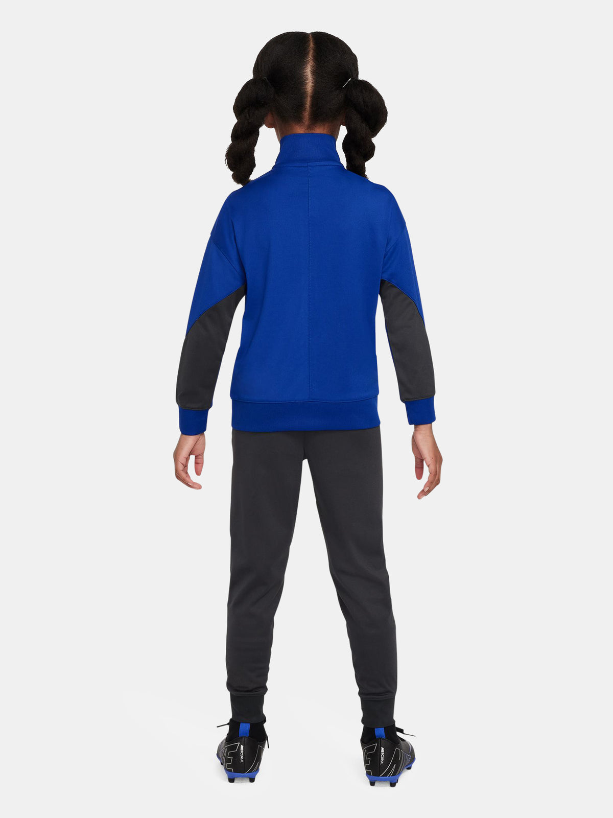 Kids' FC Barcelona tracksuit with blue jacket and black pants, featuring neon green crest and Nike logos.