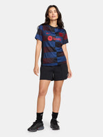 FC Barcelona warm-up shirt featuring a black base with a striking vertical stripe pattern in alternating red and blue. The shirt displays the red Spotify logo in the center, along with the Nike swoosh and FC Barcelona crest, also in red.