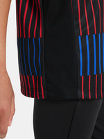 FC Barcelona warm-up shirt featuring a black base with a striking vertical stripe pattern in alternating red and blue. The shirt displays the red Spotify logo in the center, along with the Nike swoosh and FC Barcelona crest, also in red.