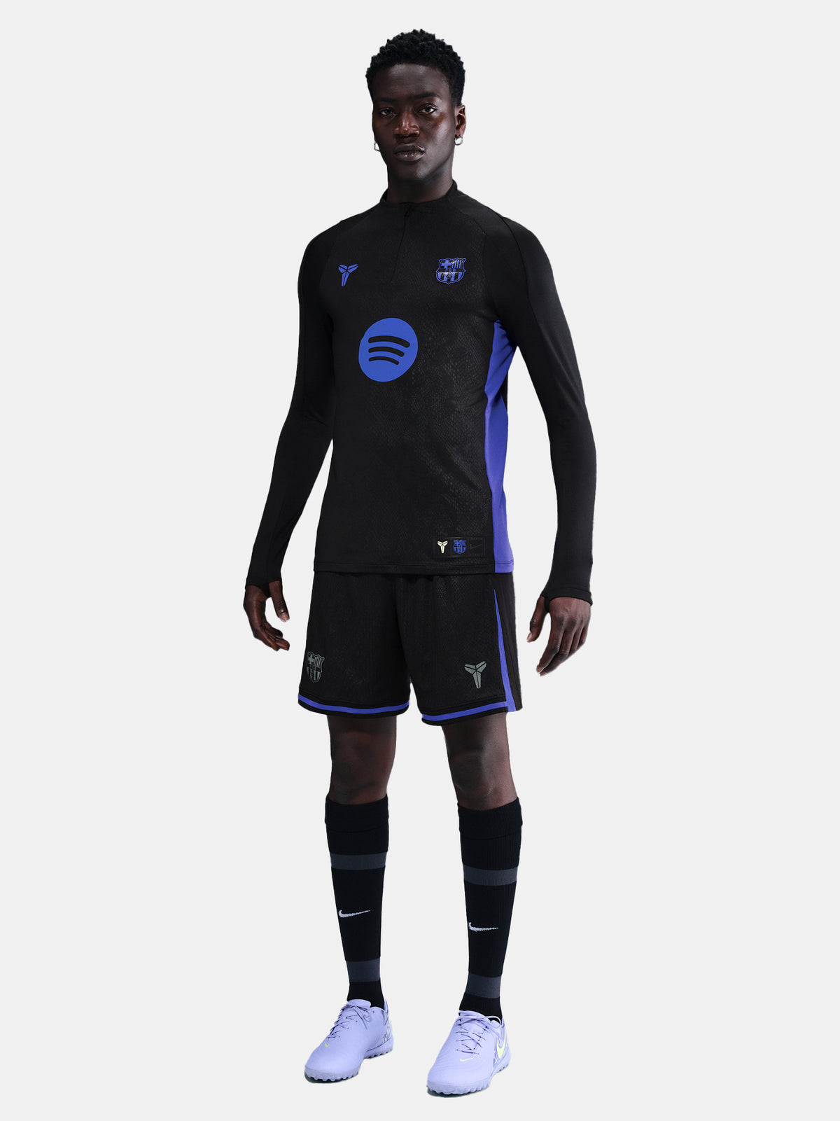 Person wearing a black and blue sports outfit with visible branding on a light gray background