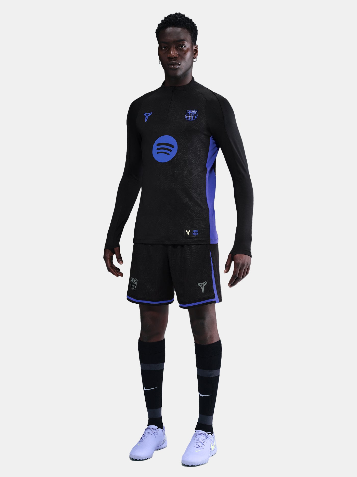 Person wearing a black and blue sports outfit with visible branding on a light gray background