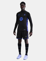 Person wearing a black and blue sports outfit with visible branding on a light gray background