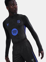 Person wearing a black athletic outfit with logos on a plain background