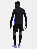 Person wearing a black athletic outfit with blue accents on a light gray background