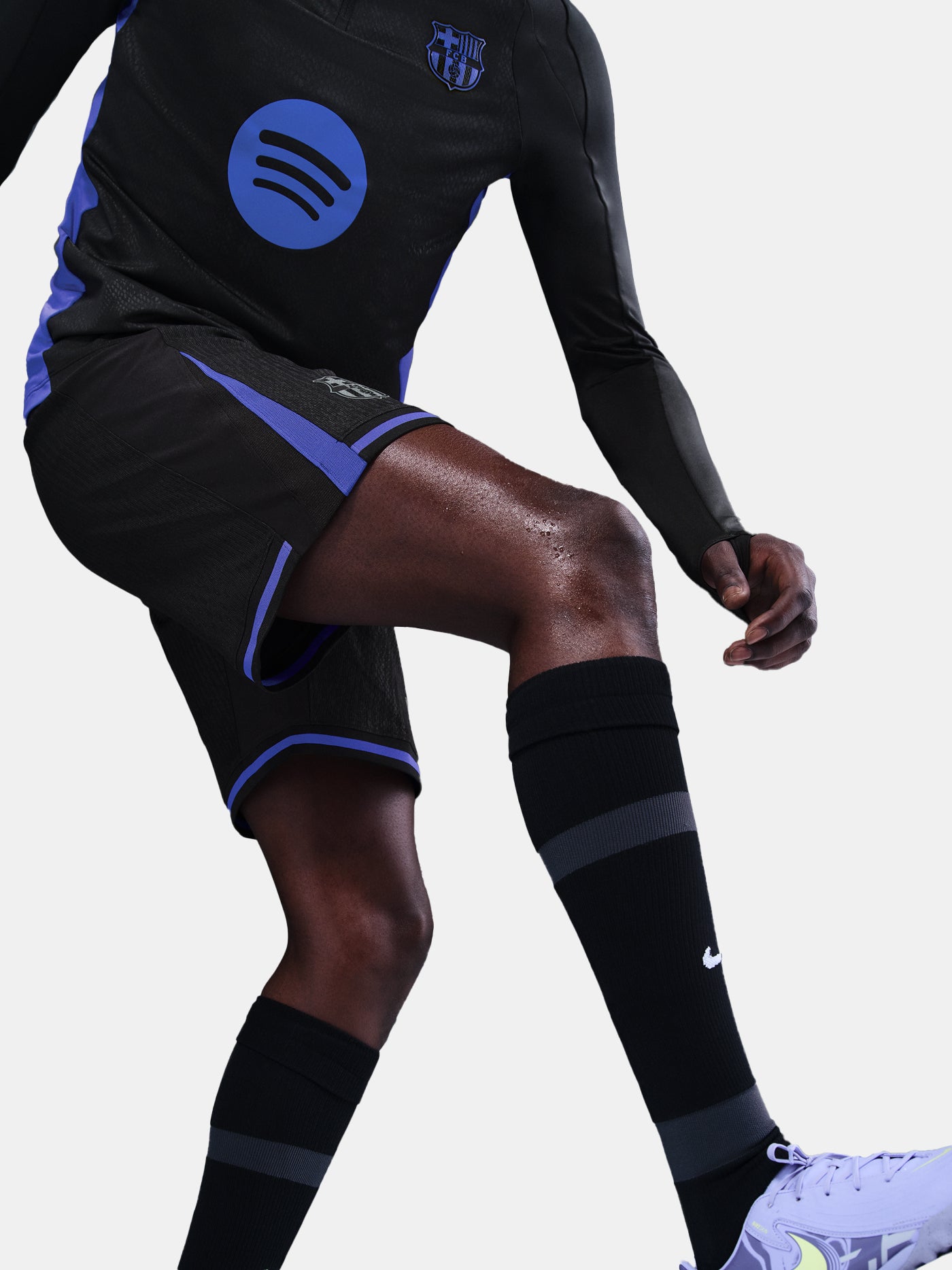 Person wearing a black sports outfit with blue accents on a white background