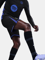Person wearing a black sports outfit with blue accents on a white background