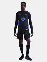 Person wearing a black sports outfit with blue accents on a white background