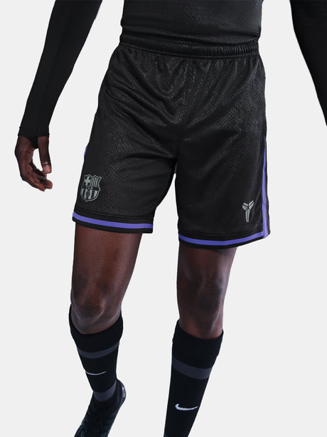 Black sports shorts with purple accents worn by a person on a white background