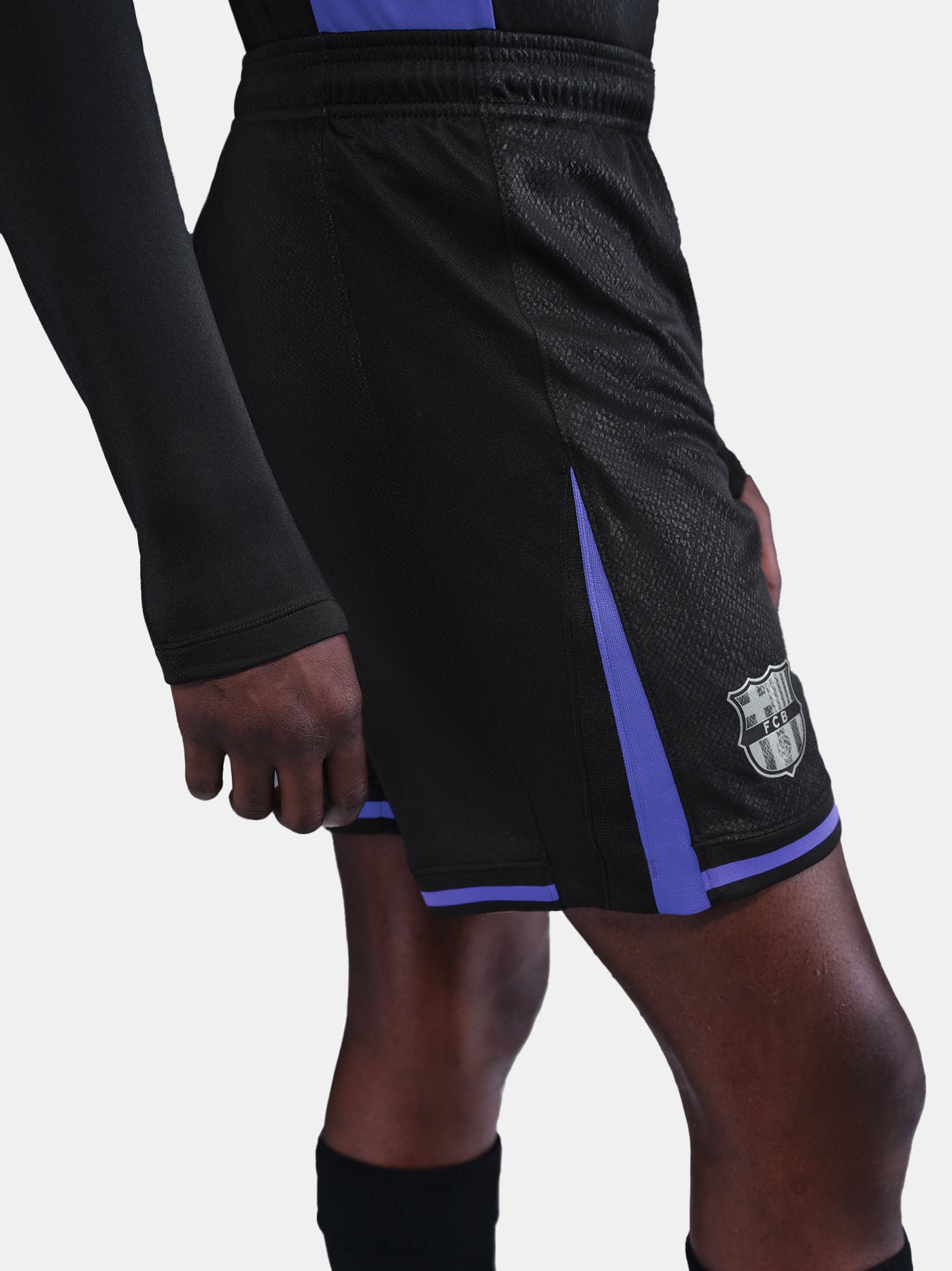 Black shorts with purple accents featuring a logo on a gray background
