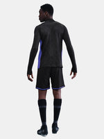 Person wearing a black athletic outfit with purple accents on a white background