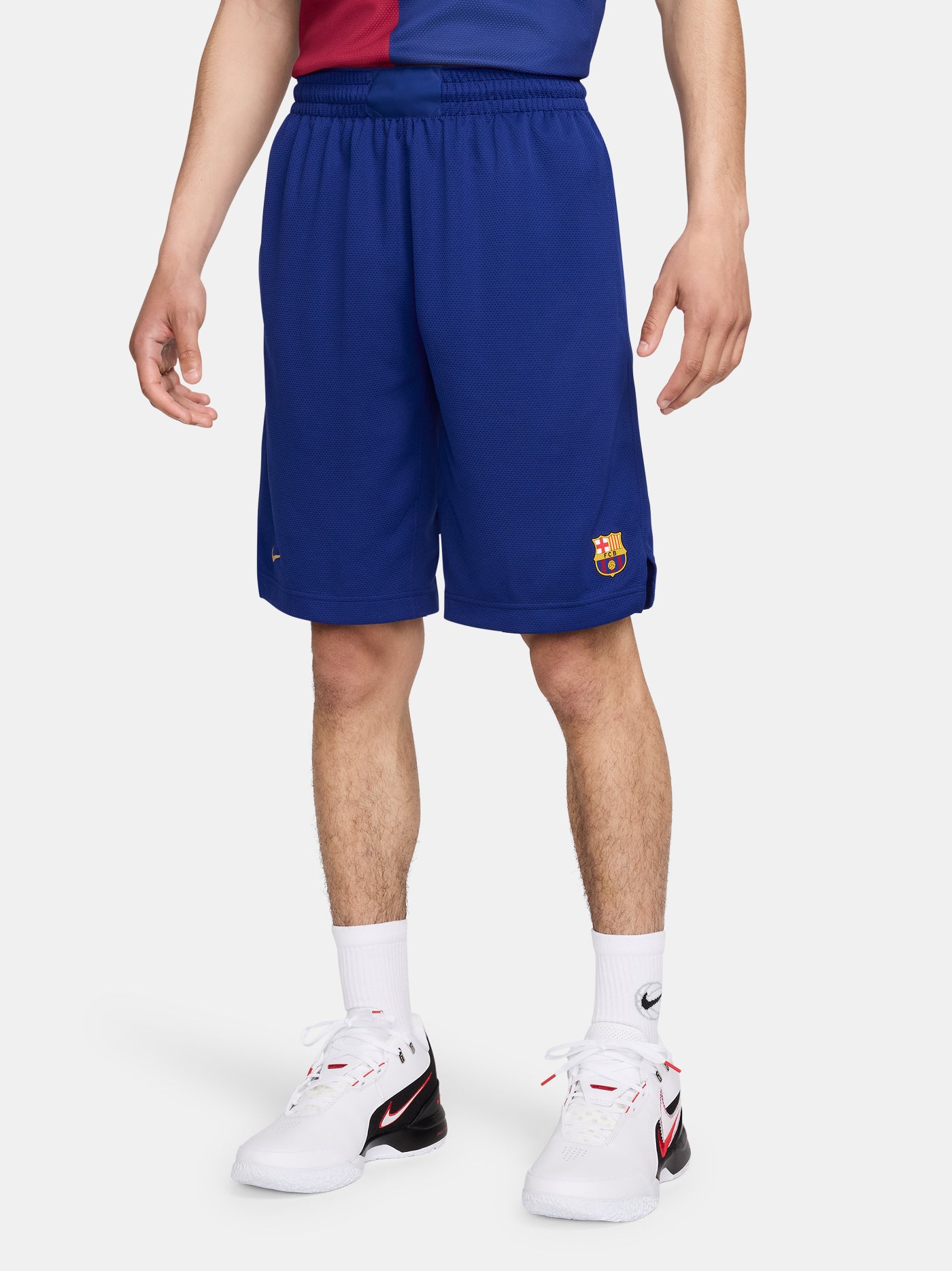Man wearing blue FC Barcelona shorts featuring the club crest and Nike logo.