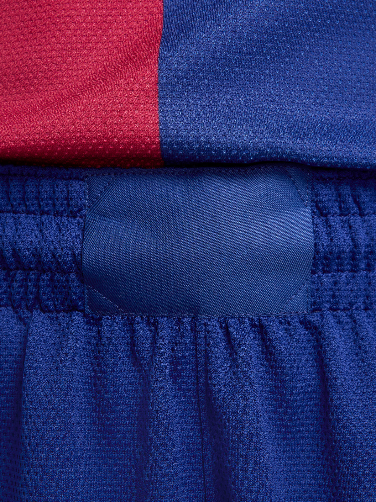 Man wearing blue FC Barcelona shorts featuring the club crest and Nike logo.